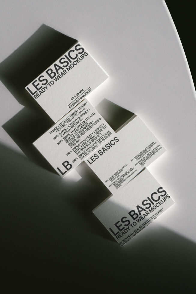 Three stacked clothing tags with Les Basics branding in black, white, grey with care info