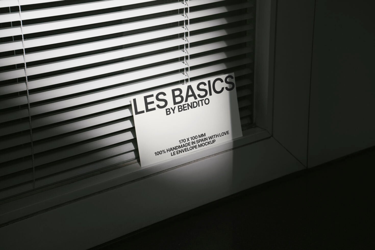 Envelope mockup titled Les Basics by Bendito, placed against blinds with a minimalist design. Ideal for graphic designers. Keywords: mockup, design, envelope.