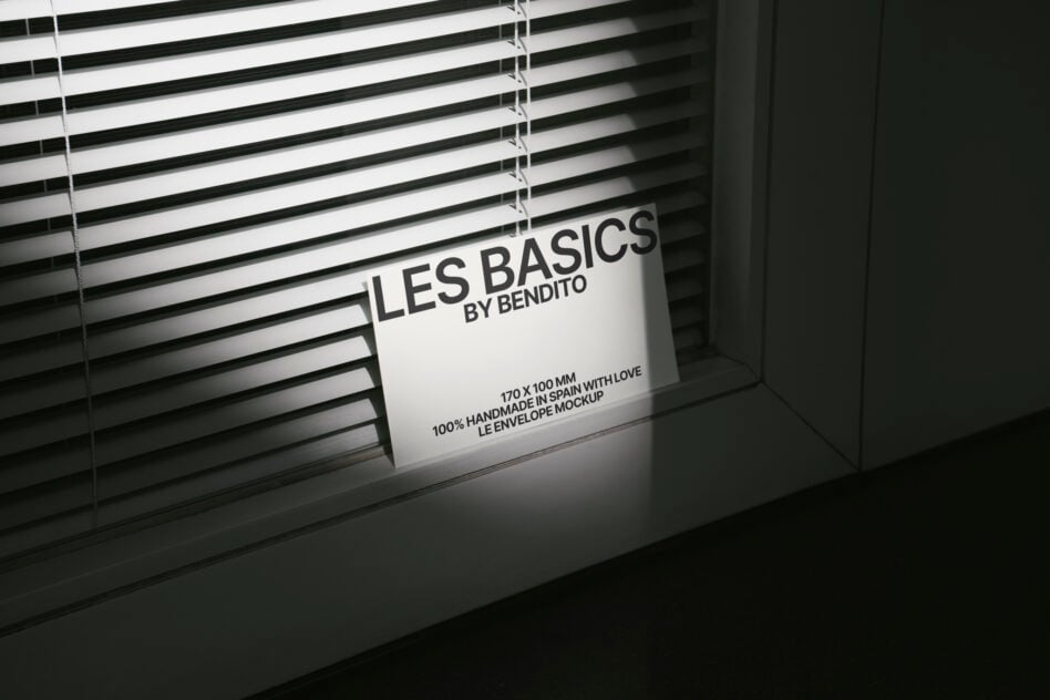 Les Basics business card mockup lit by window blinds creating striped shadow