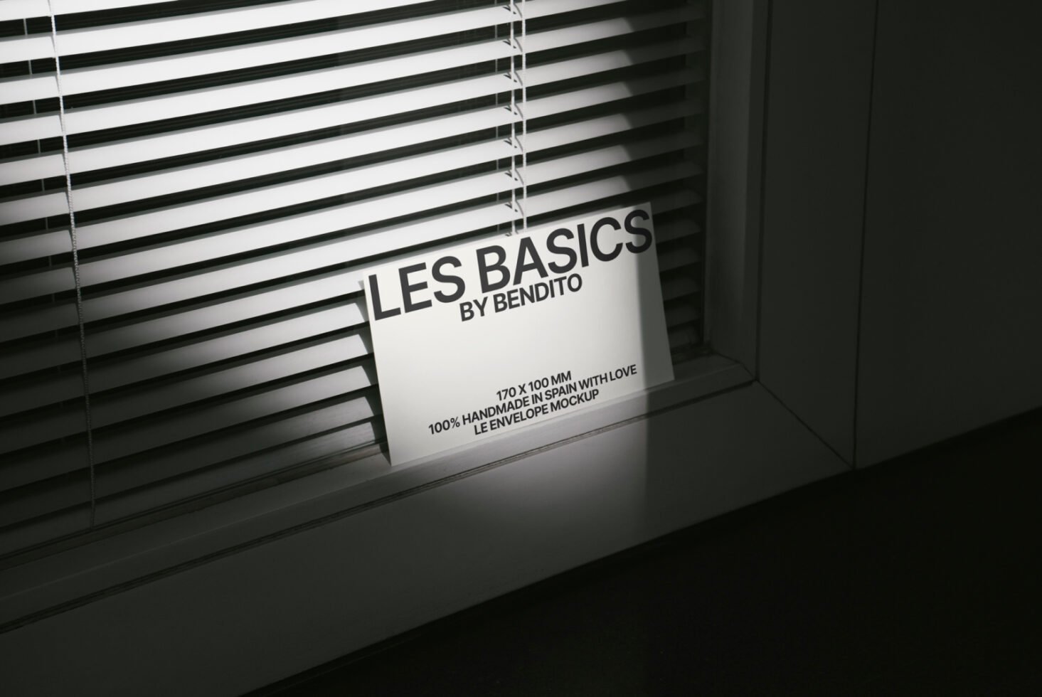 Envelope mockup in front of blinds showcasing Les Basics by Bendito. Ideal for designers seeking high-quality mockups with shadows for branding projects.