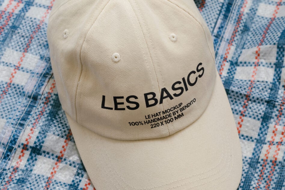 Beige cap mockup with Les Basics text on geometric textile background ideal for designers seeking customizable hat templates or fashion design assets