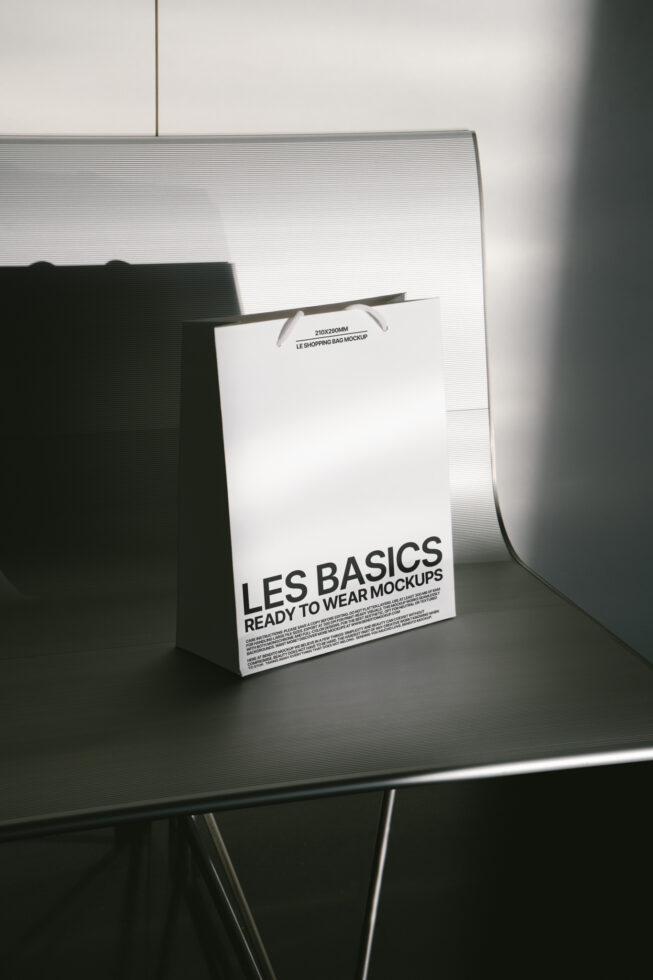 White shopping bag mockup with rope handles tilted on surface