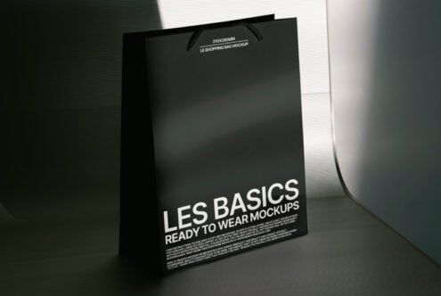 Black shopping bag mockup in a lit setting ideal for fashion packaging design featuring minimalist aesthetics and customizable branding templates.