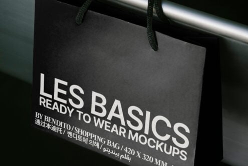 Shopping bag mockup with black design and white text. Ideal for branding and retail presentations. Keywords: mockup, shopping bag, design asset.
