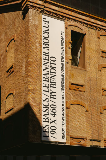 Cream banner mockup on red brick facade with Korean text, architectural window frames visible