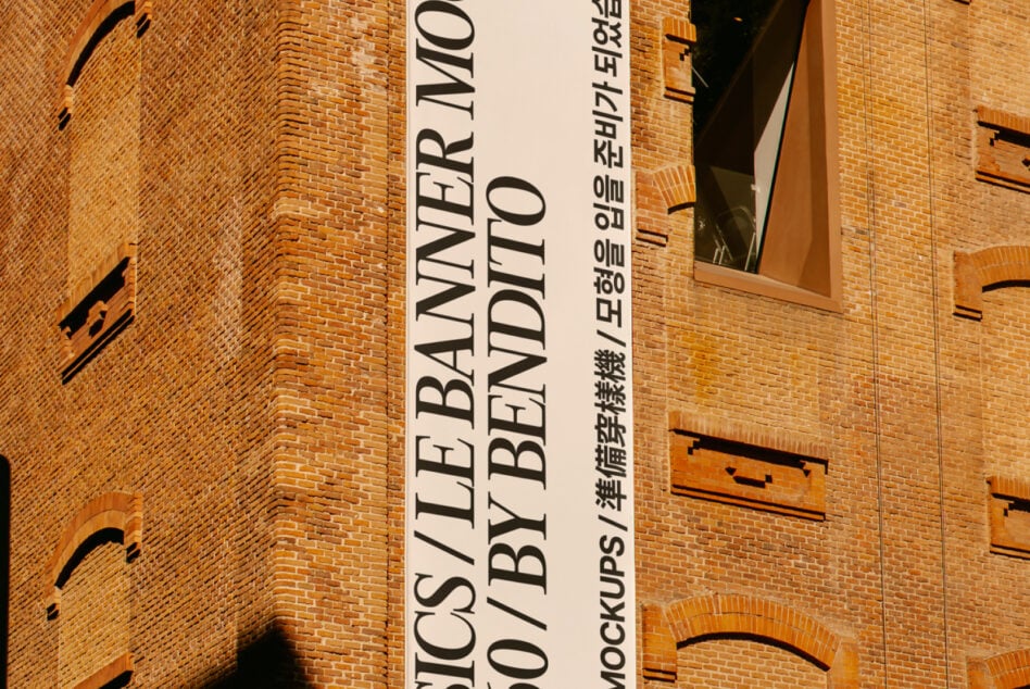 Light banner on warm brick wall with bilingual typography, arched windows, golden hour lighting