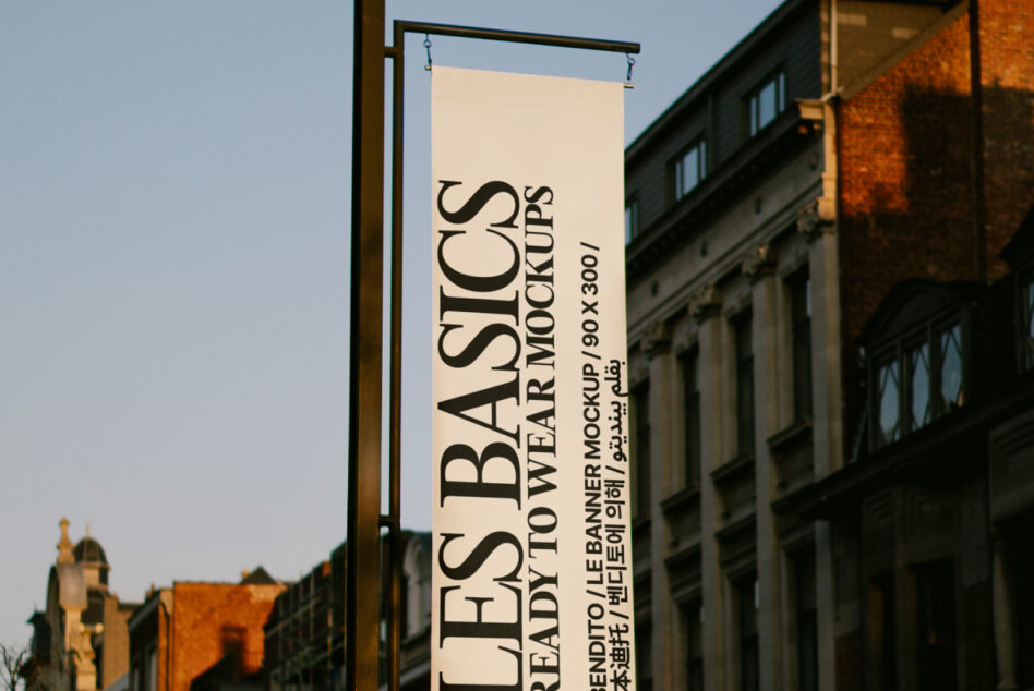 Vertical banner hanging on street pole with Les Basics text in serif font
