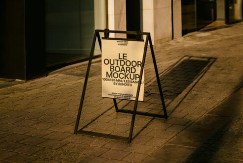 Outdoor board mockup for designers featuring a street sign on a sidewalk with afternoon shadows ideal for showcasing branding graphics or advertisements.