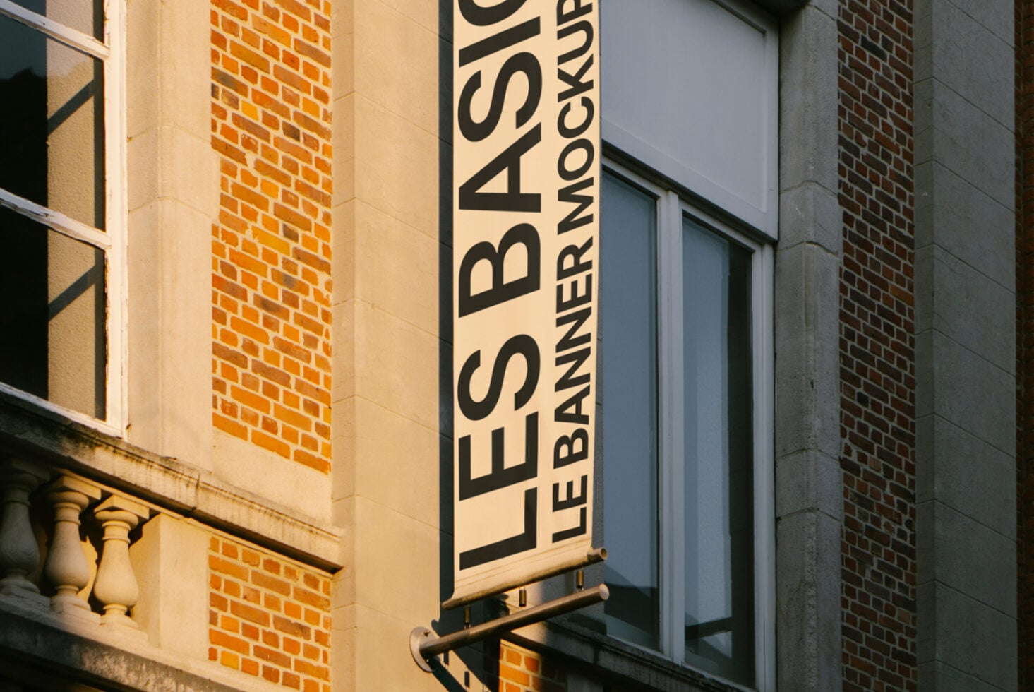 Building mounted banner mockup showing Les Basics Le Banner text vertically