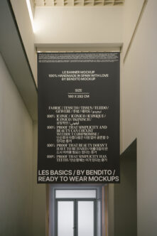 Dark banner mockup hanging in corridor with multilingual text about fabric