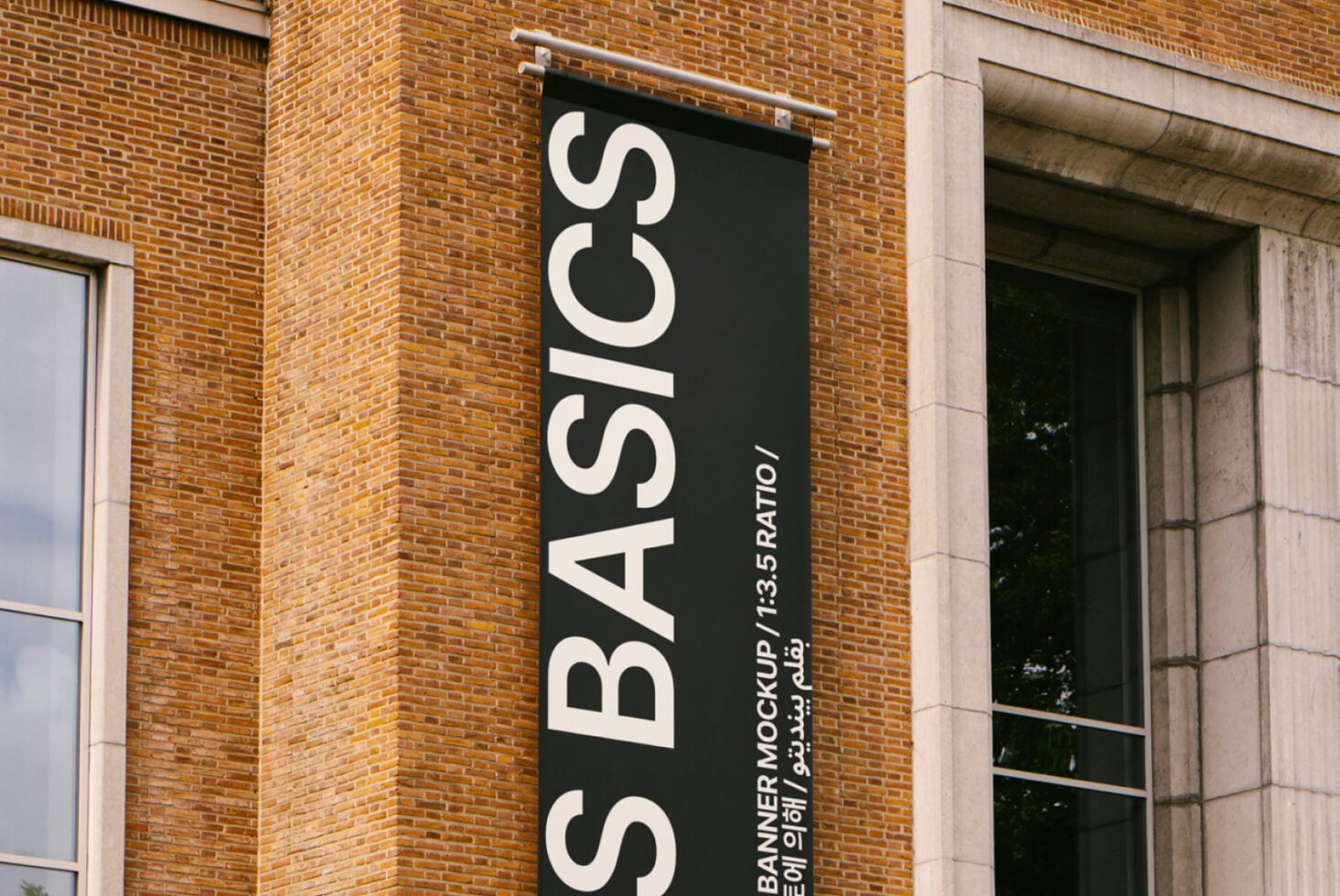 Black vertical banner mockup on brick building with white large text S BASICS