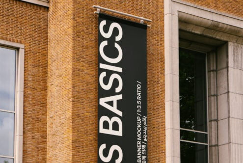 Vertical banner mockup on a brick building showcasing a modern design with a 1 to 3.5 ratio ideal for outdoor advertising graphics and signage templates