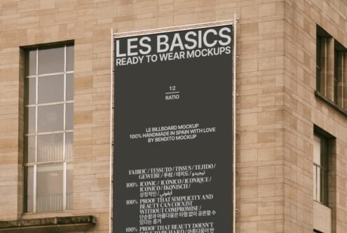 Urban billboard mockup on brick building showcasing Les Basics ready to wear graphics in multiple languages for designer templates and branding visuals.