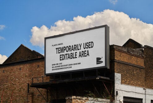 Outdoor billboard mockup on brick building against blue sky with clouds. Editable area for design. Ideal for advertising template and promotional graphics.