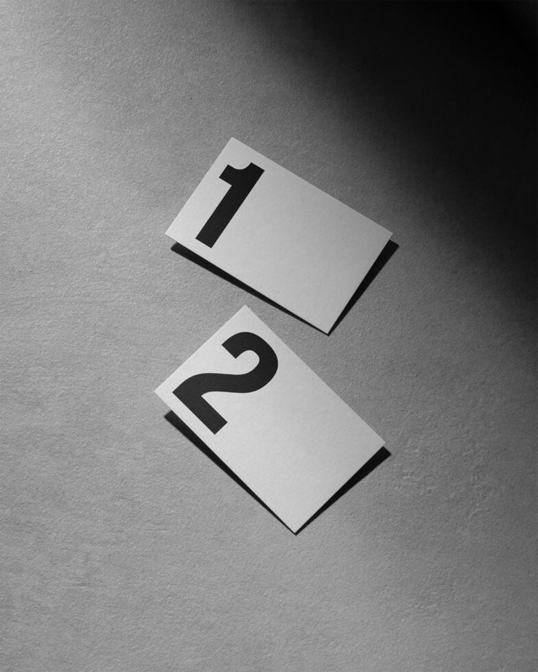 Numbers mockup with cards displaying one and two in modern typography on textured gray background perfect for minimalist design projects.