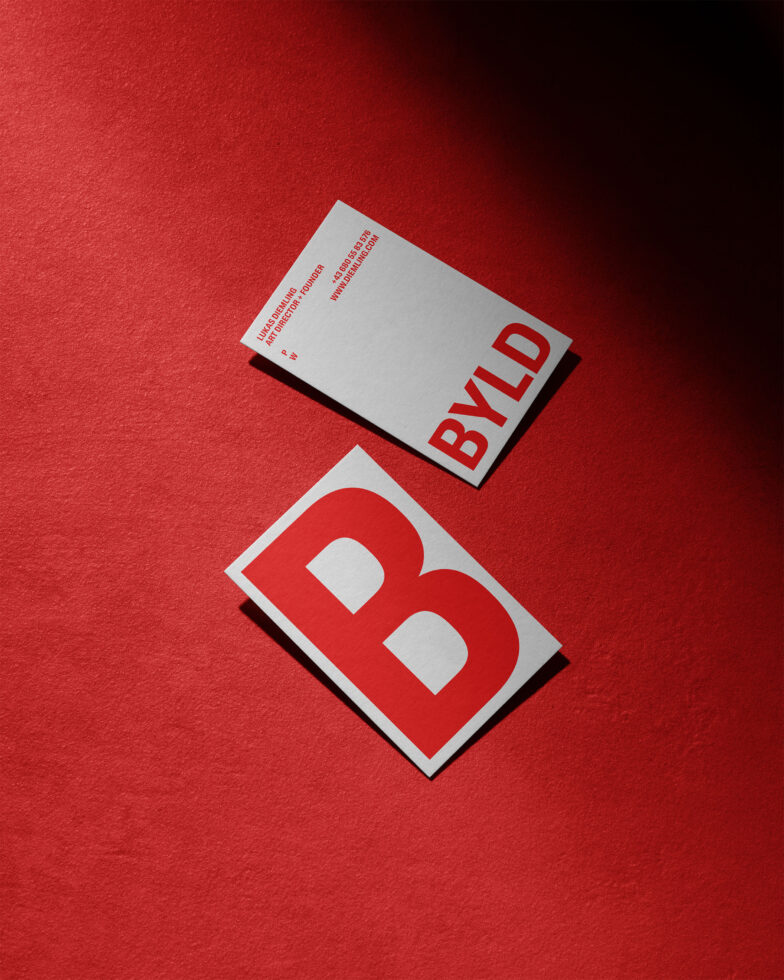 Business card mockup on a textured red background featuring bold minimalist typography in red and white ideal for designers branding templates graphics