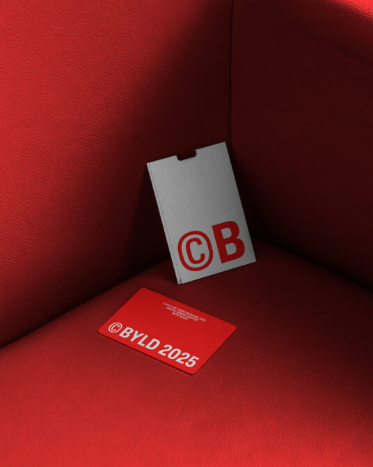 Gray business card with red CB logo on textured red fabric background