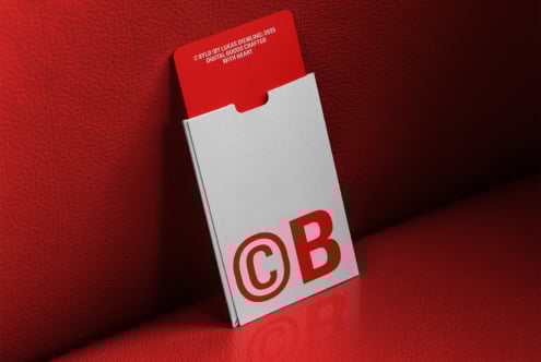 Minimal business card mockup with bold red CB logo partially in a white sleeve against a red textured background perfect for branding projects.