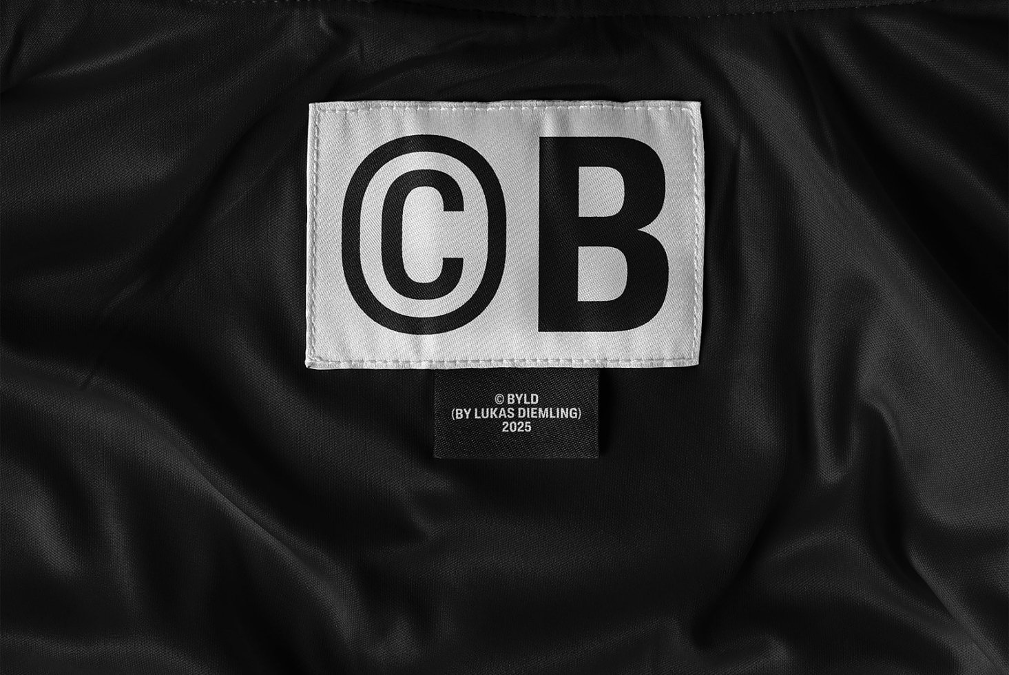 Close-up of a black clothing label with bold typography design digital asset for designers ideal for mockups templates branding projects fashion.