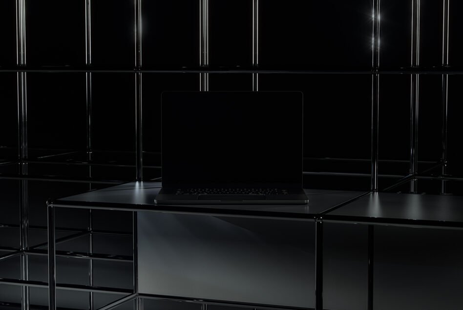 Laptop with blank screen on glass table in futuristic neon-lit space