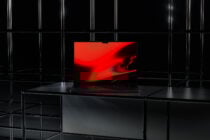 Laptop mockup with vibrant red abstract display on a sleek black metal grid background perfect for digital design presentations and showcasing templates