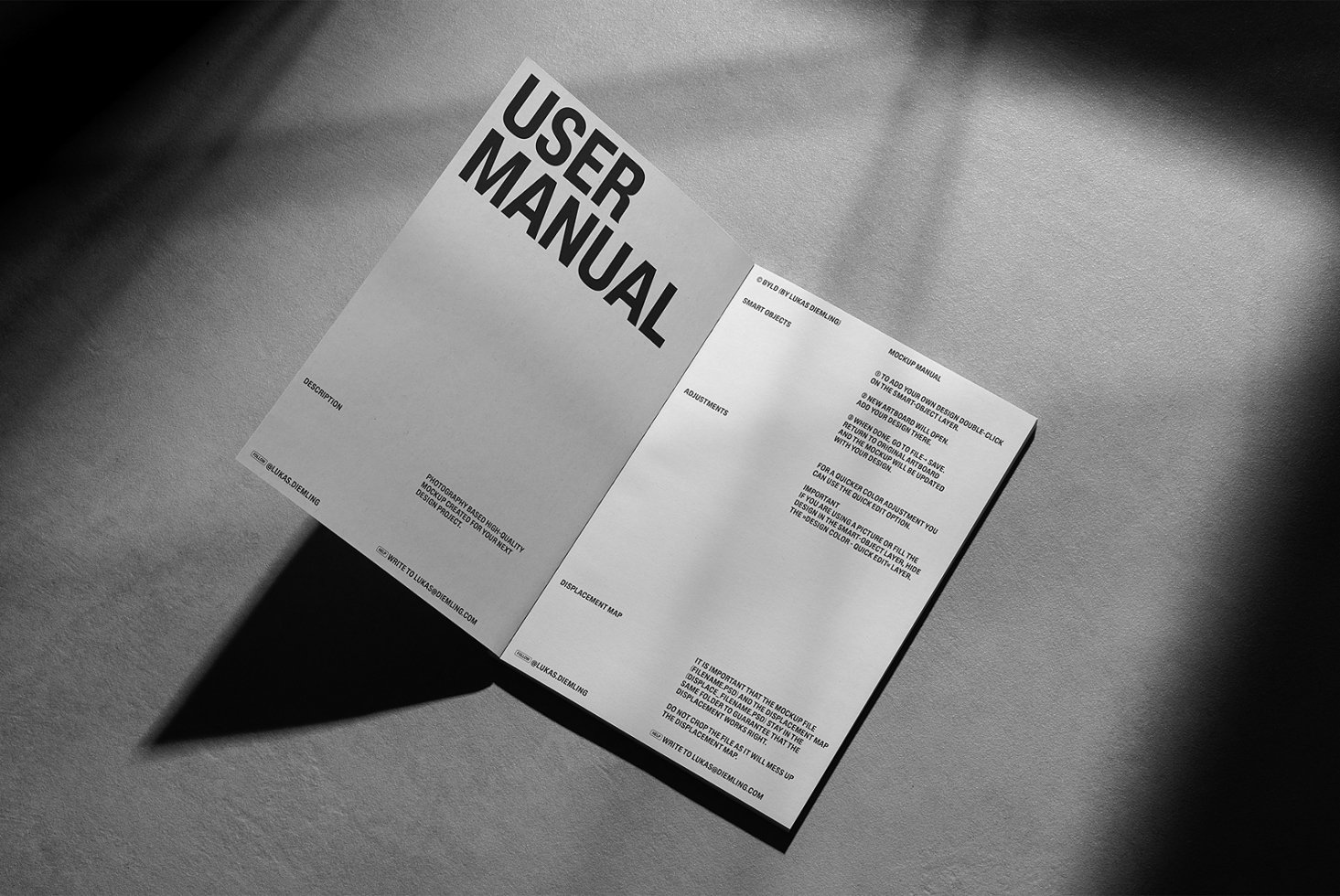 Open user manual mockup on a textured surface with shadows. Ideal for designers needing book or brochure mockups. High-quality, realistic presentation.