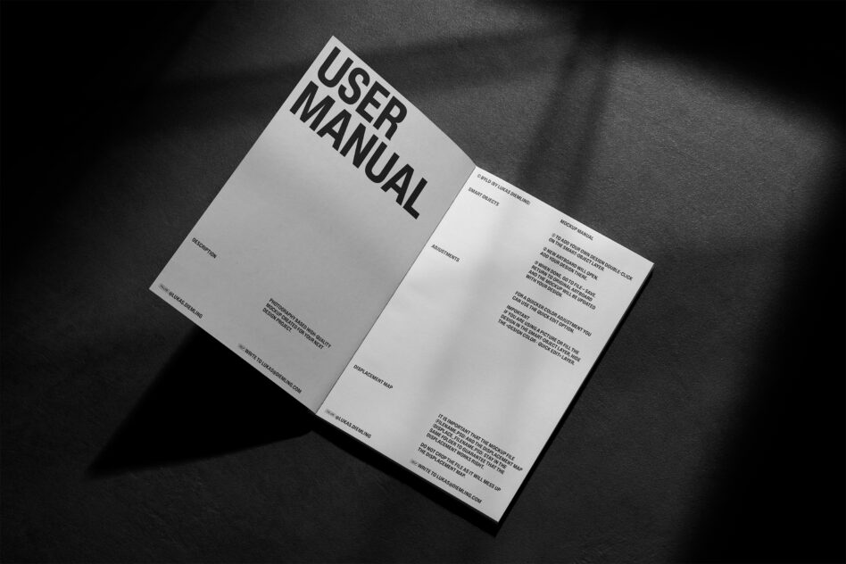 Open user manual booklet with text visible on right page, dark moody lighting
