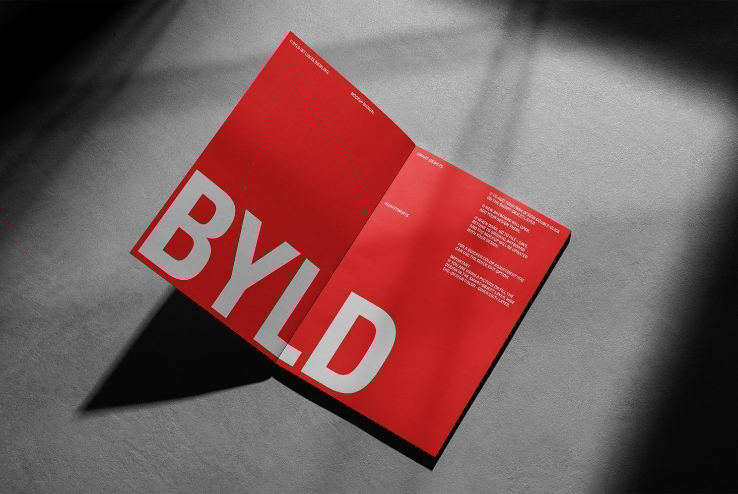 Red open booklet mockup on textured surface featuring bold white typography and informational text. Ideal for graphic designers seeking stylish templates.