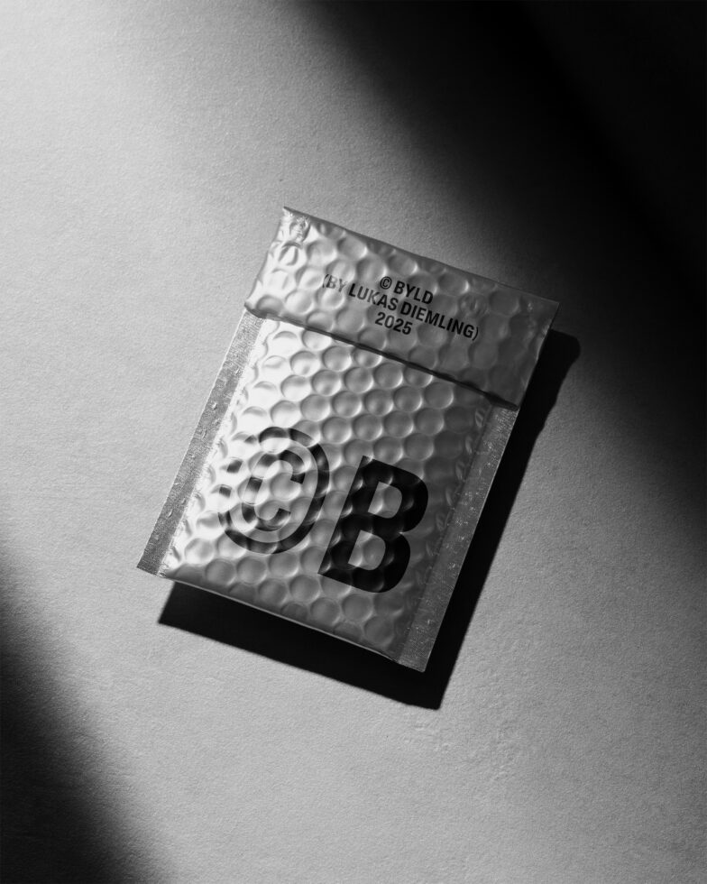 Black and white image of a bubble mailer with bold typography on the front by BYLD Lukas Diemling 2025. Ideal for product mockup and packaging design.