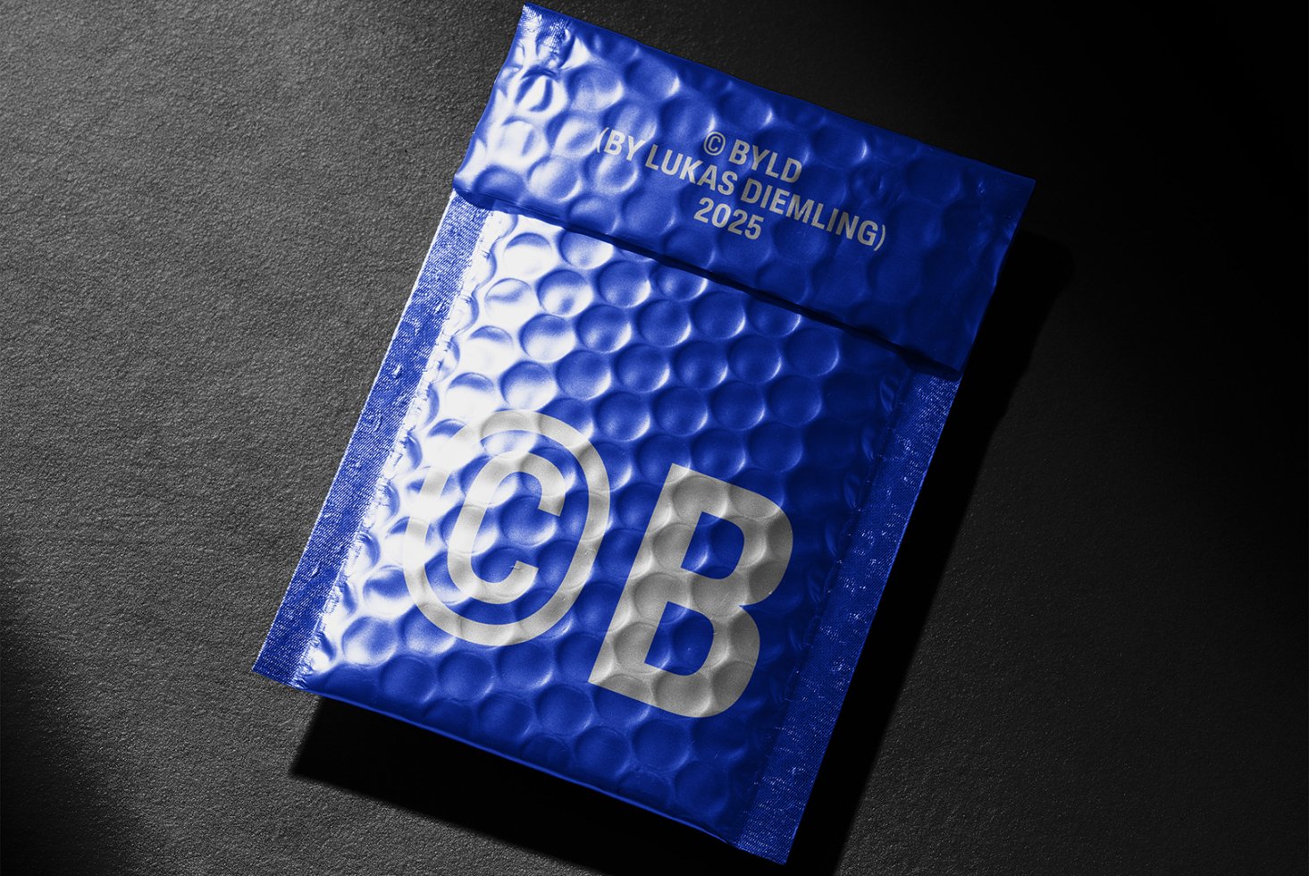 Blue bubble mailer mockup with copyright symbol on dark background. Perfect for designers seeking innovative packaging templates or graphic projects.