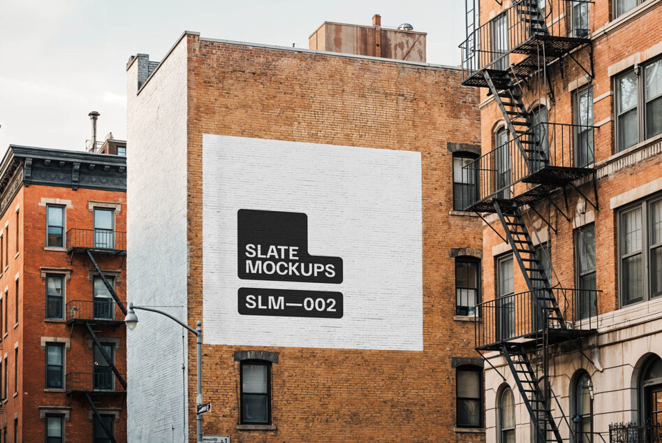 White painted wall mockup with black stencil branding on brick facade
