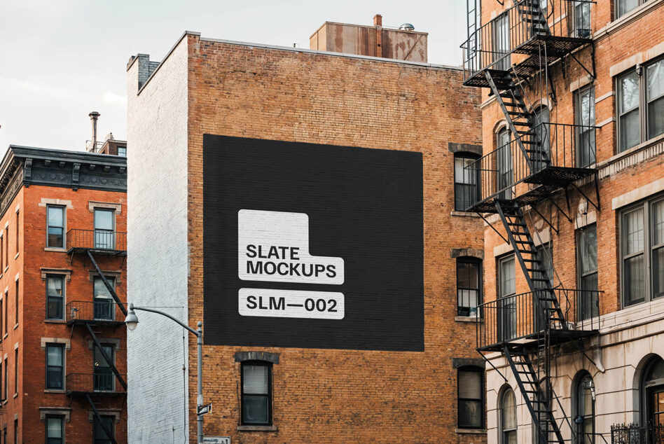 Dark storefront mural with white stencil logos on industrial brick