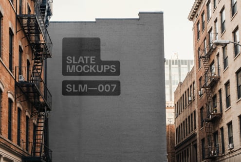 Urban building wall mockup for graphic designers showcasing a large gray brick surface in a city alley ideal for advertising and presentation use