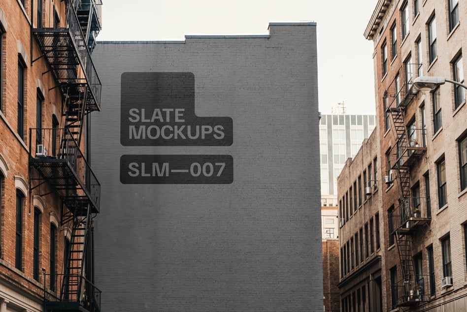 Dark brick building wall with slate mockups text overlay in urban alley