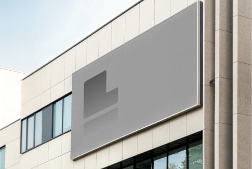 Building facade with a large blank billboard, ideal for outdoor advertising or signage mockup. Perfect for design presentations and branding projects.
