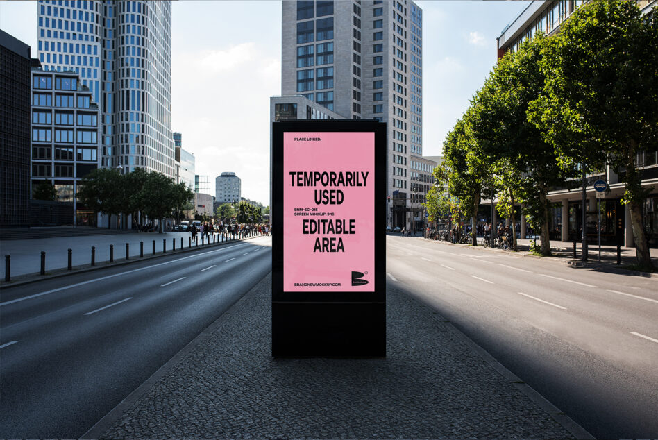 Street kiosk with bright pink vertical poster display in busy urban plaza