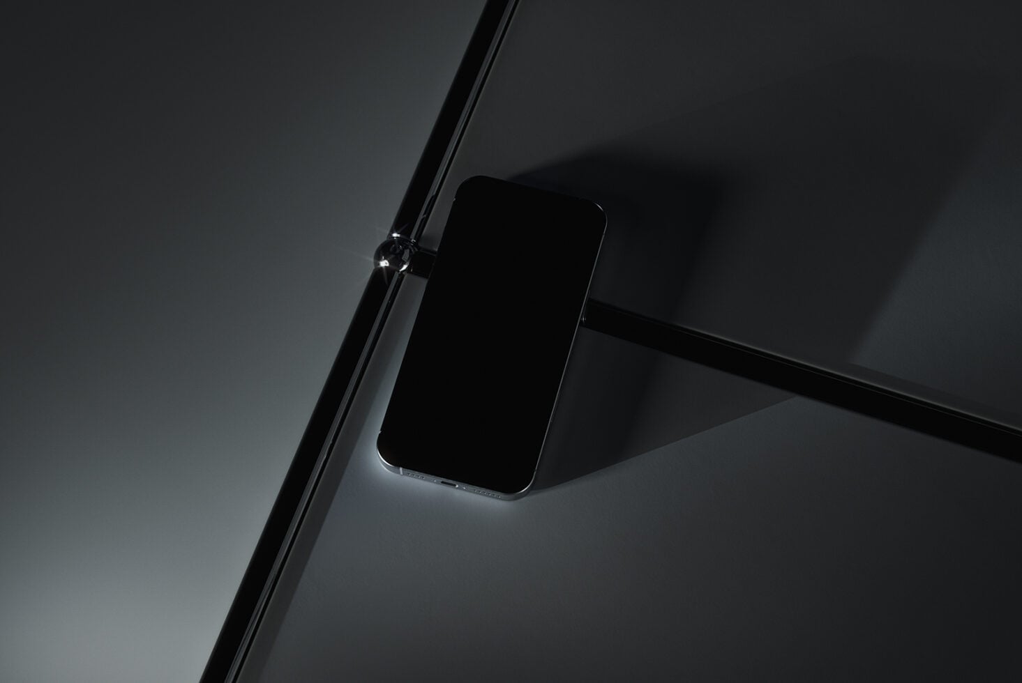 Dark smartphone mockup at angle with minimal studio lighting setup