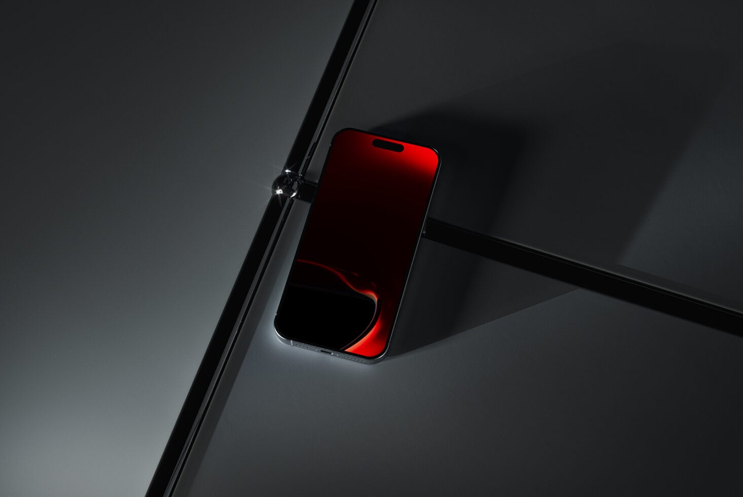 Red smartphone with glowing screen mounted on black metal rod against gray background