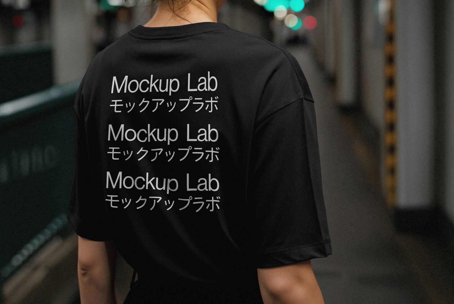 Back of a black t-shirt featuring Mockup Lab text in English and Japanese. Ideal for apparel mockup designs in urban settings for creative designers.