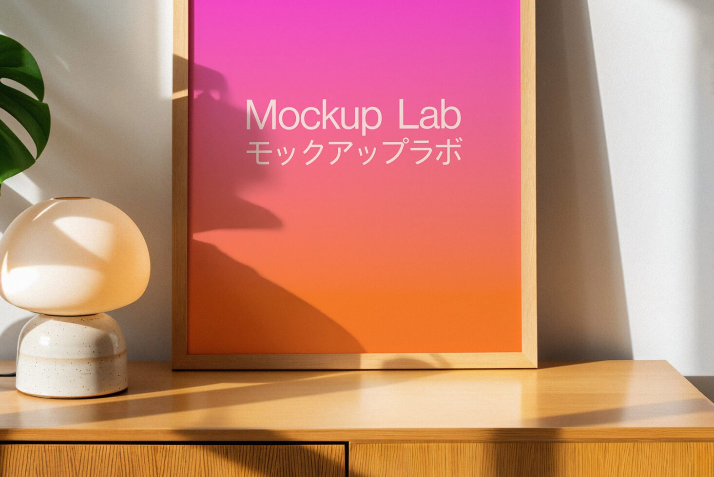Framed gradient poster mockup on a wooden shelf with modern lamp and plant. Perfect for design presentations. Keywords: mockup, poster, design.