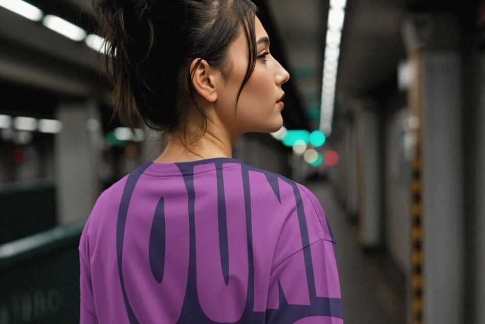 Person from behind in purple shirt with layered typography design at night