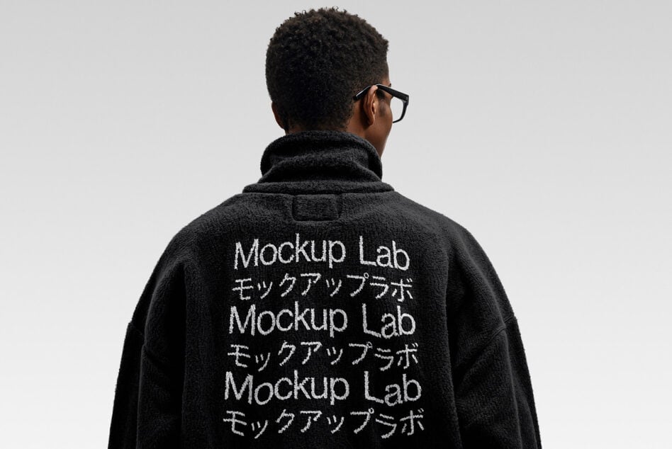 Black fleece jacket back view with white embroidered repeating text design