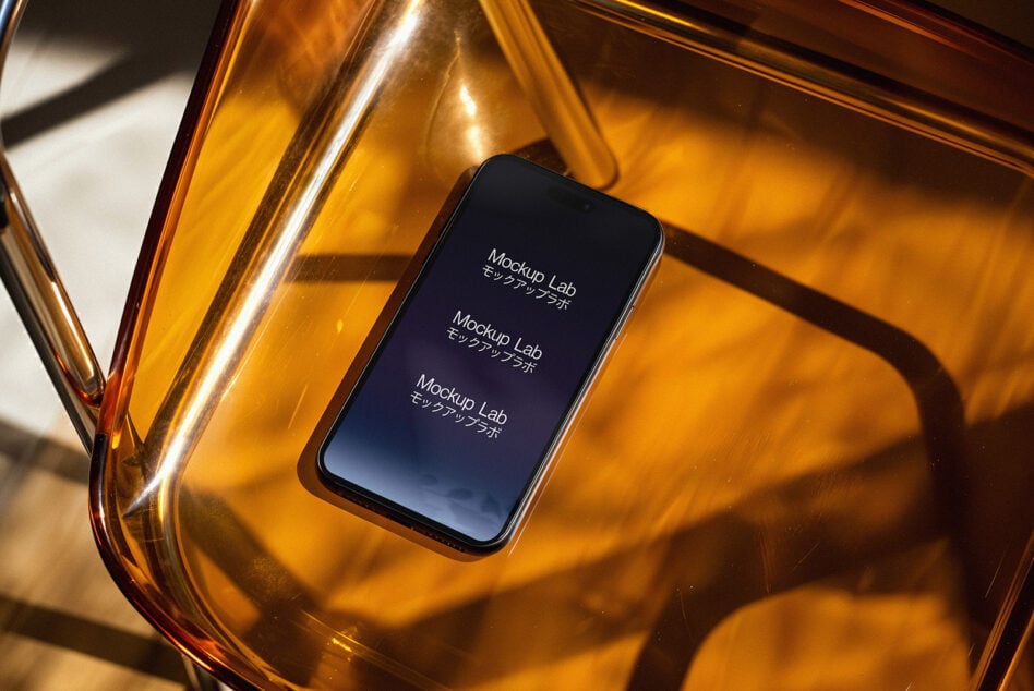 Smartphone mockup resting on a transparent amber chair surface exhibiting elegant shadows ideal for showcasing app interfaces or digital designs.