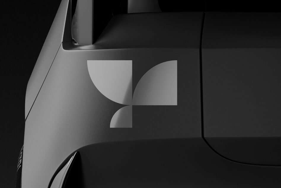Minimalist vehicle mockup featuring a sleek geometric logo on a dark surface, ideal for branding and design presentations.