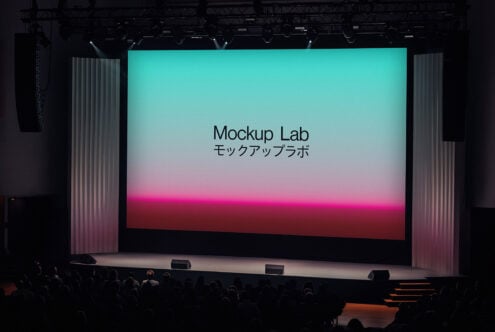 Large stage with an illuminated screen displaying Mockup Lab design conference. Audience in silhouette. Ideal for event mockup or presentation template.