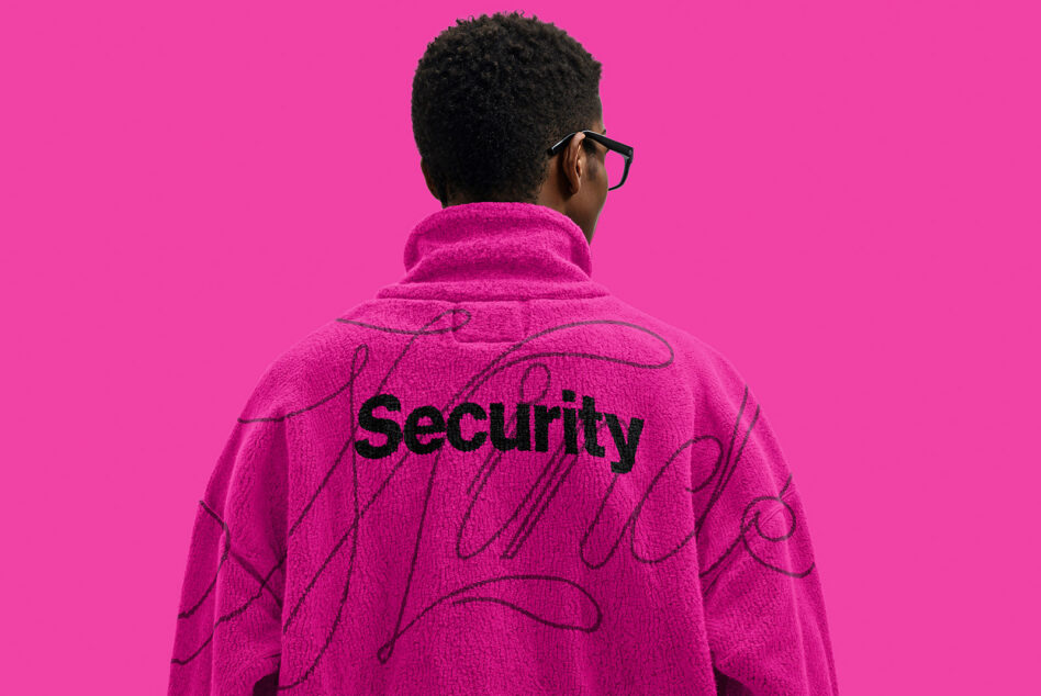 Person wearing hot pink fleece jacket with black back print against bright background