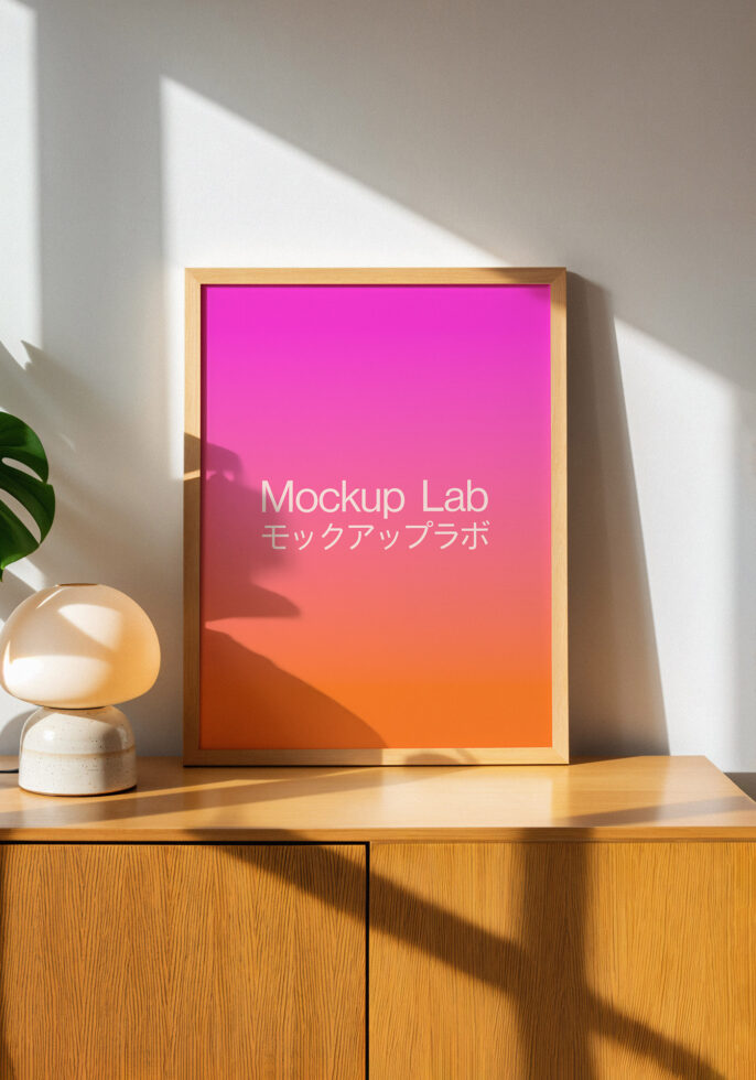 Poster mockup in a wooden frame on a wooden cabinet with soft light and shadows. Gradient pink to orange background. Ideal for design presentations.
