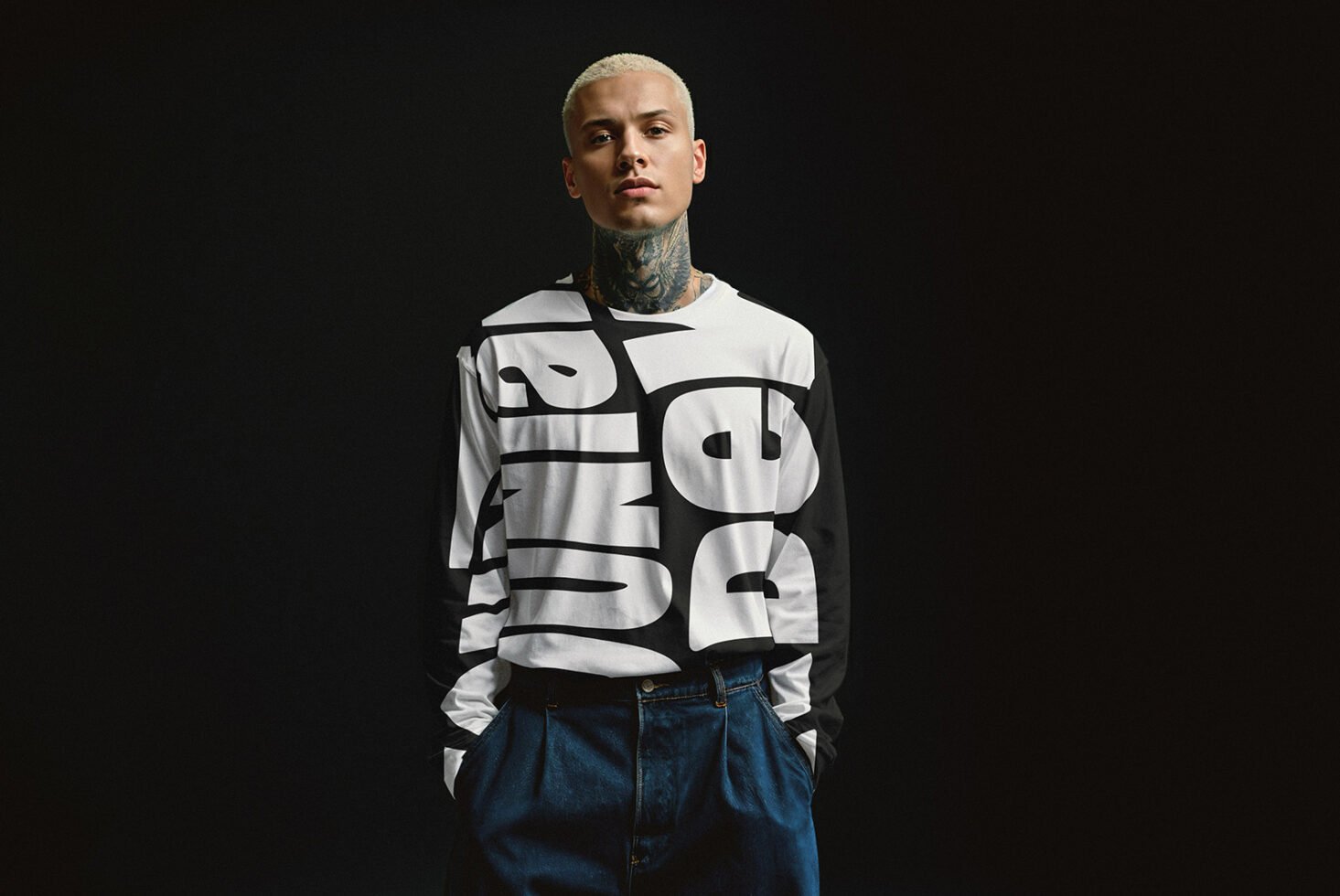 Model wearing a graphic black and white long-sleeve shirt with bold typography. Fashion mockup for graphic design, typography, and apparel design.