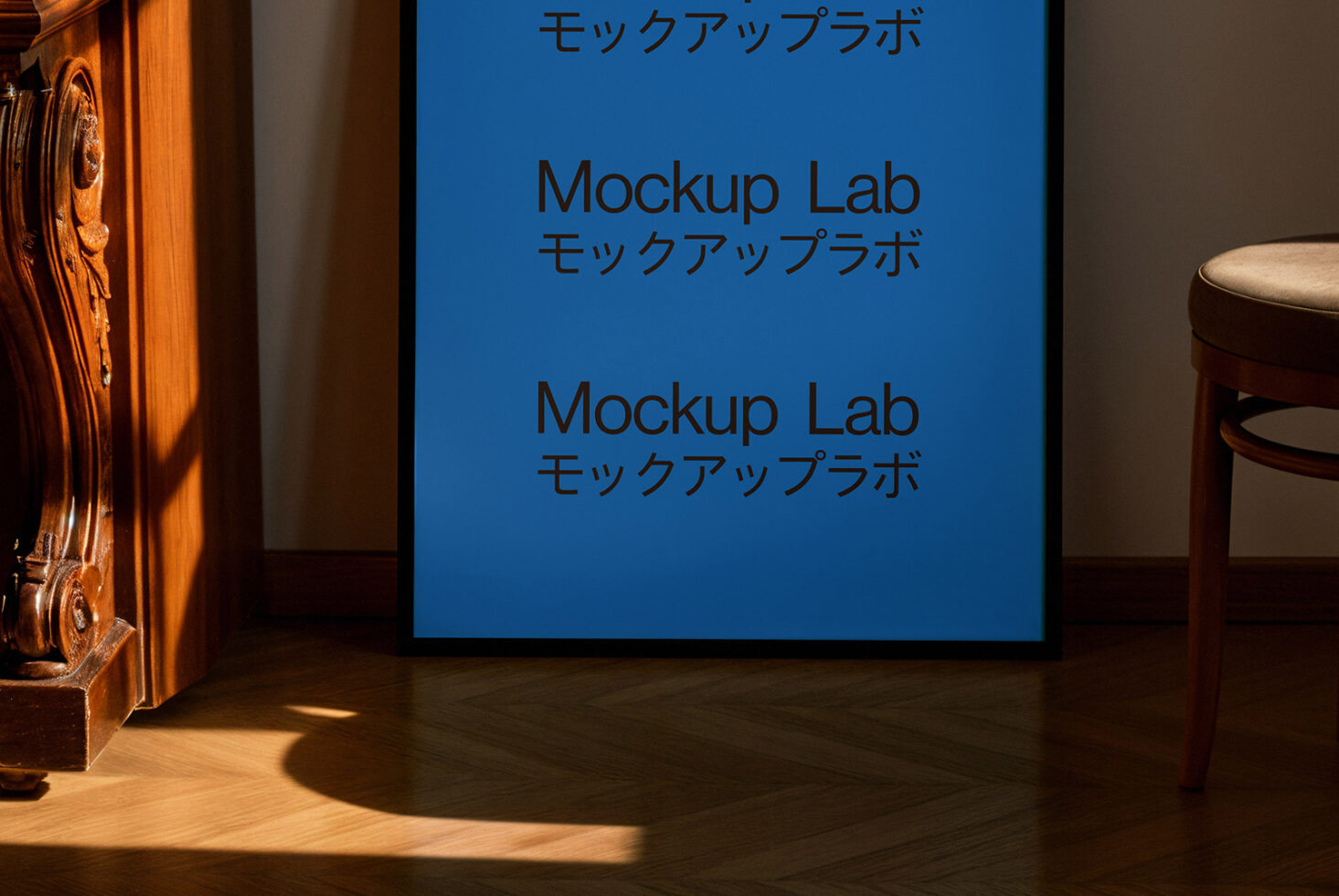 Framed poster mockup in a room with wooden furniture displaying Mockup Lab text in English and Japanese. Ideal for designers in search of mockup templates.
