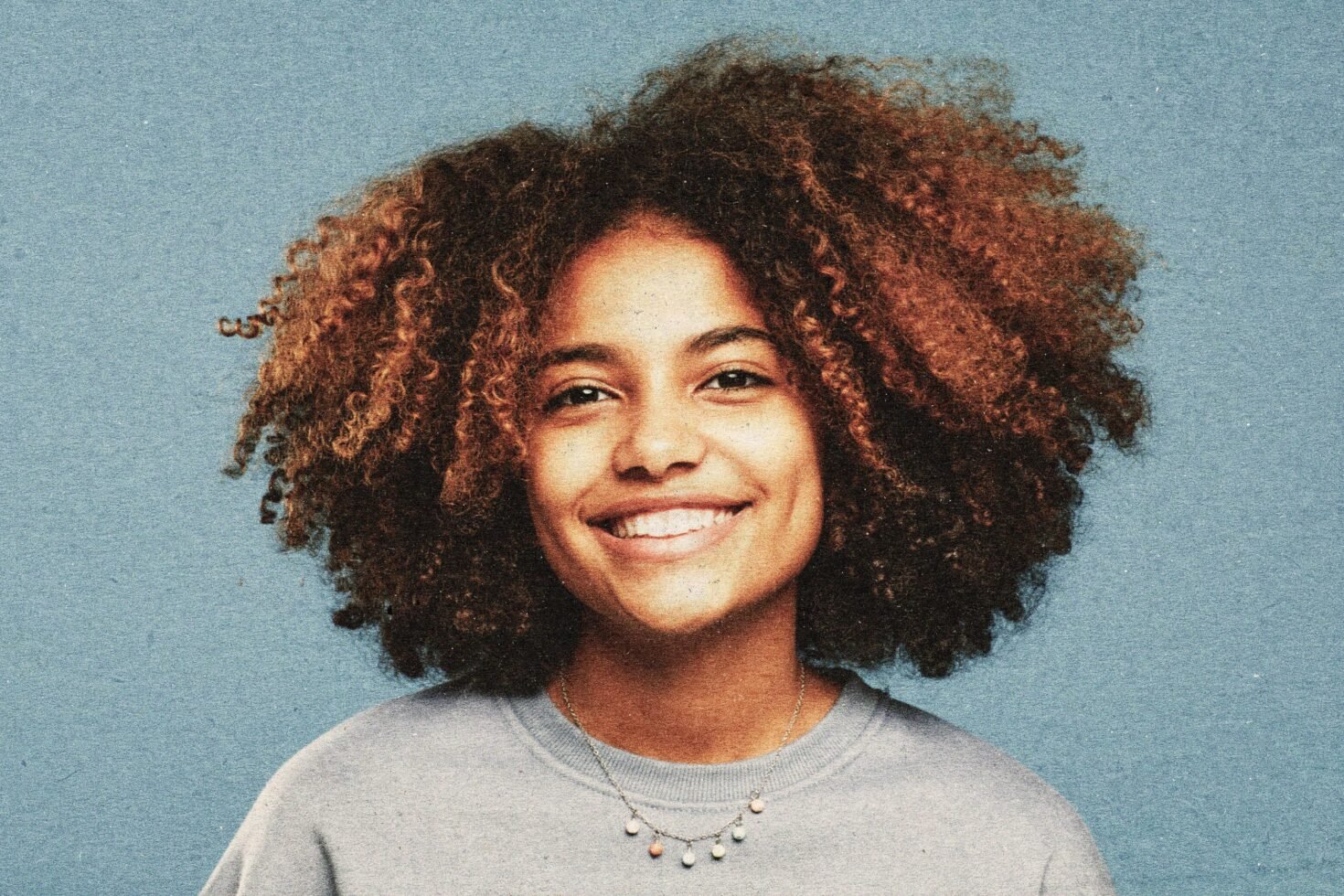 Portrait of a cheerful person with curly hair against a blue textured background ideal for graphic design mockups and templates digital asset.